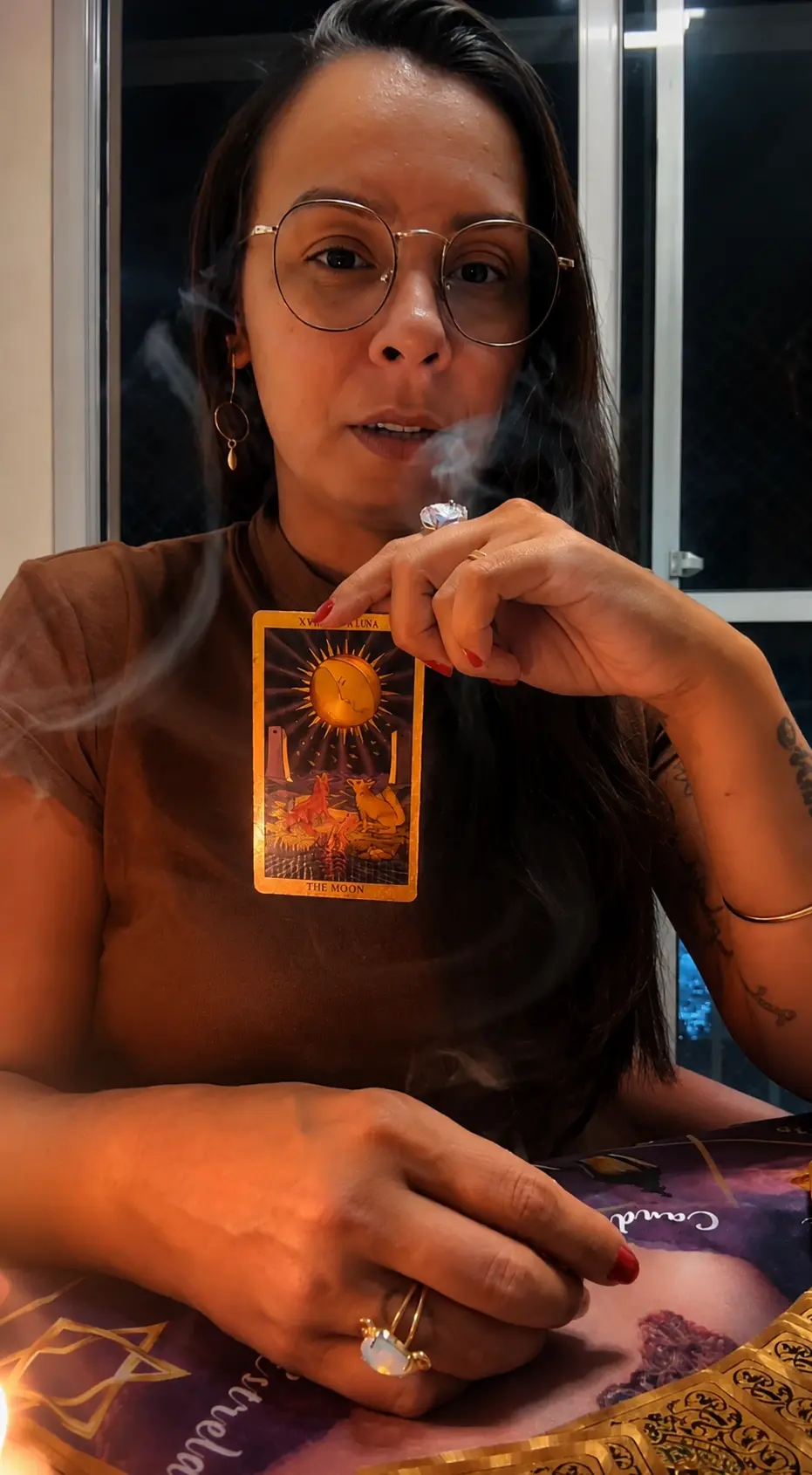 Lorraine segurando a carta A Lua entre a fumaça do incenso